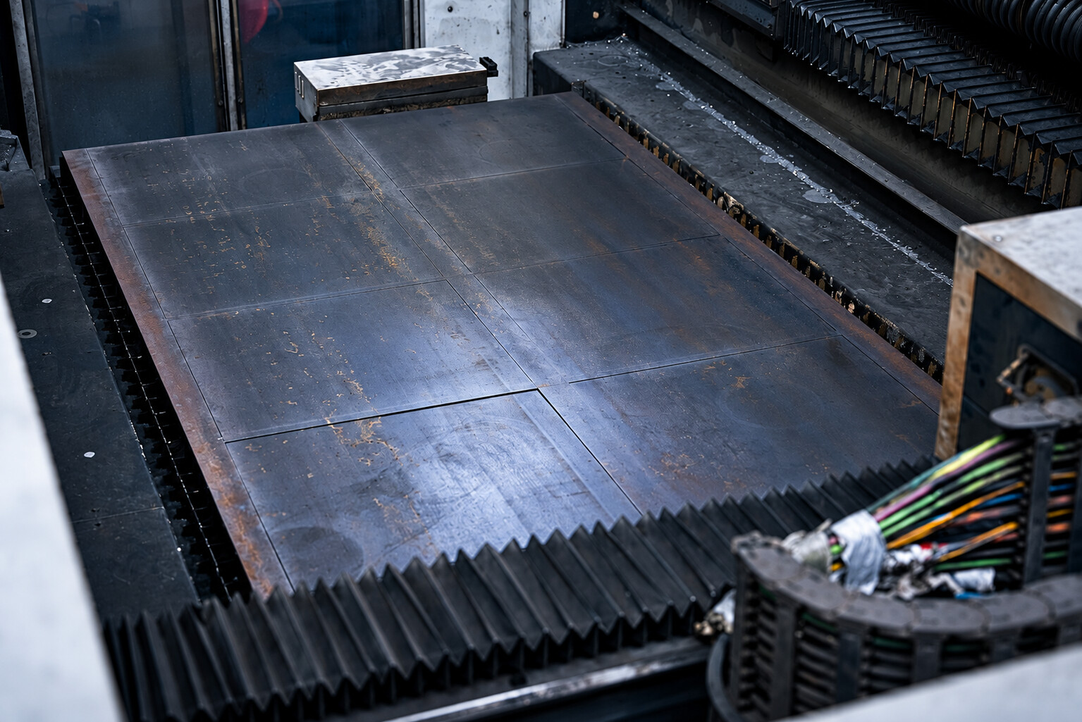 Metallblech in einer Laserschneidanlage bei ACROSS Solutions in Metal.