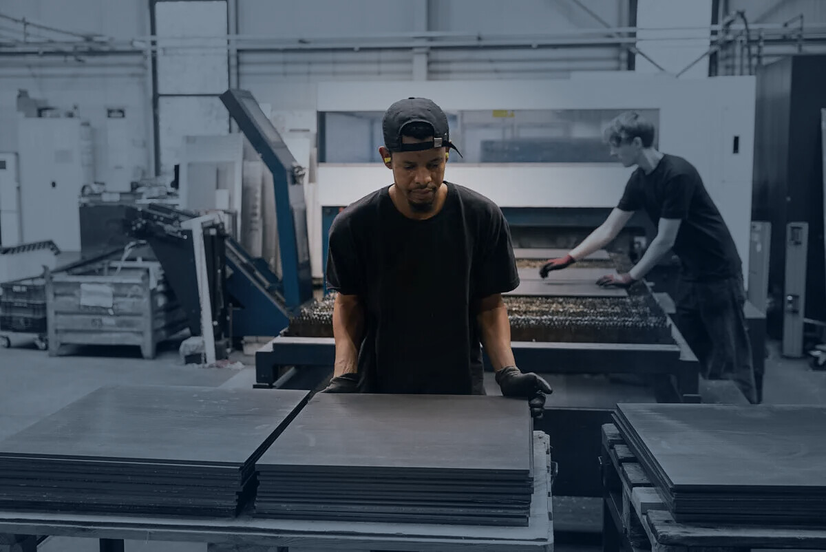 Mitarbeiter von ACROSS Solutions in Metal bei der Bearbeitung von Metallblechen.