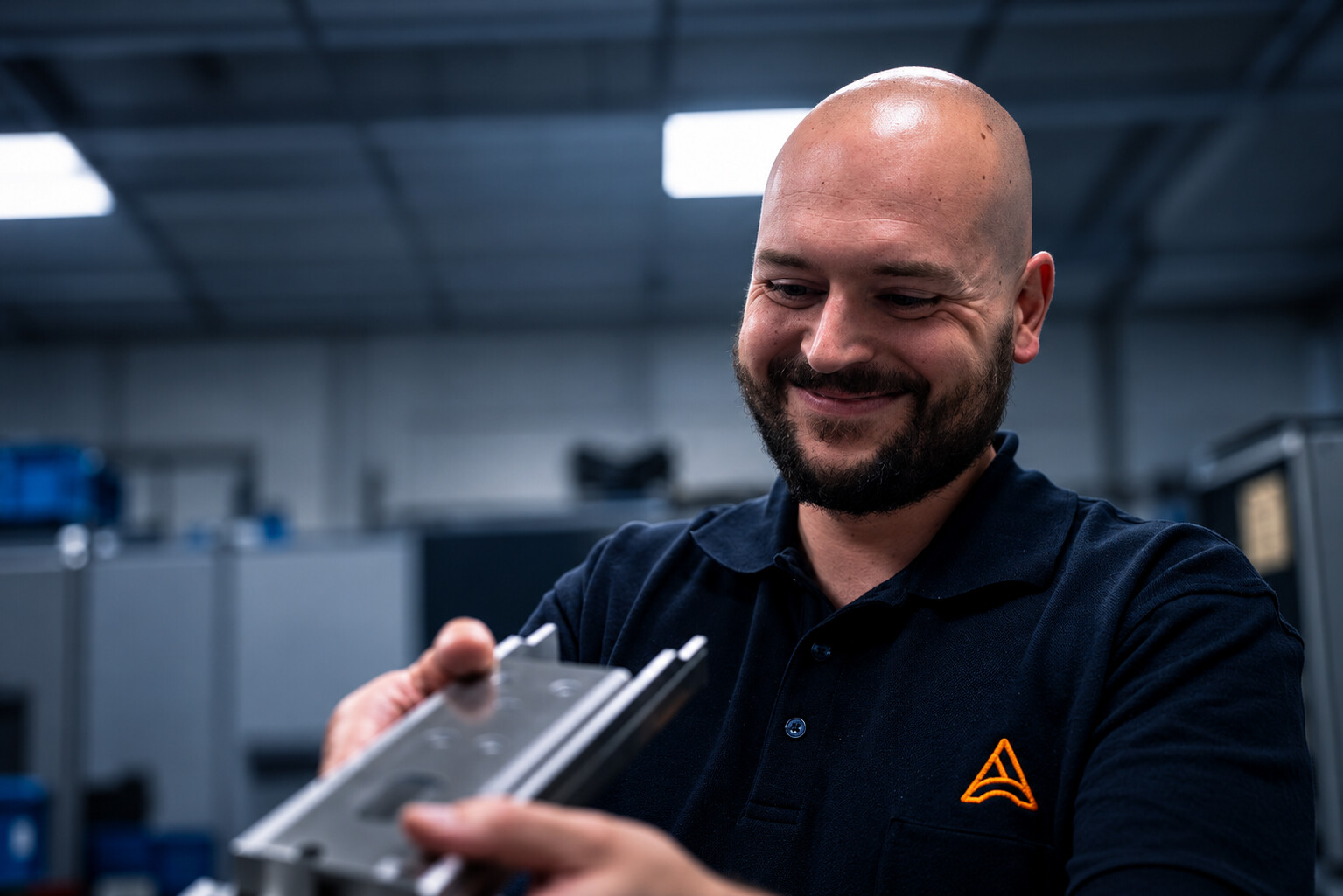 Mitarbeiter prüft ein Metallbauteil bei ACROSS Solutions in Metal