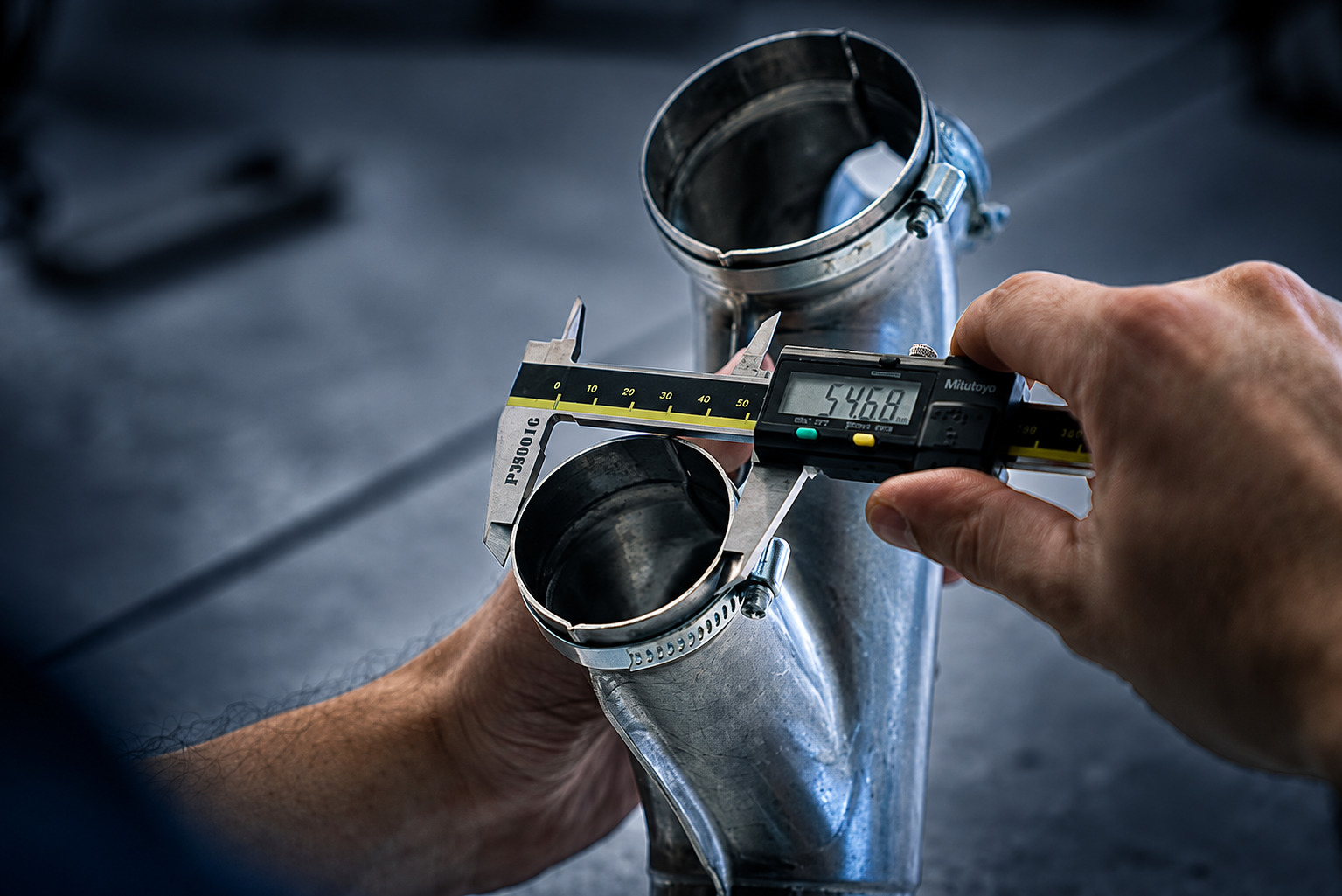 Qualitätsprüfung eines Metallbauteils mit digitalem Messschieber bei ACROSS Solutions in Metal
