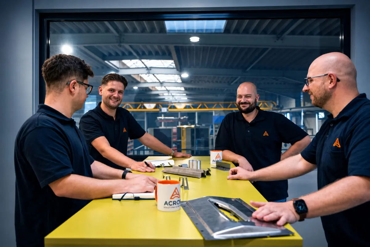 Team von ACROSS Solutions in Metal bei der Besprechung von Metallbauteilen